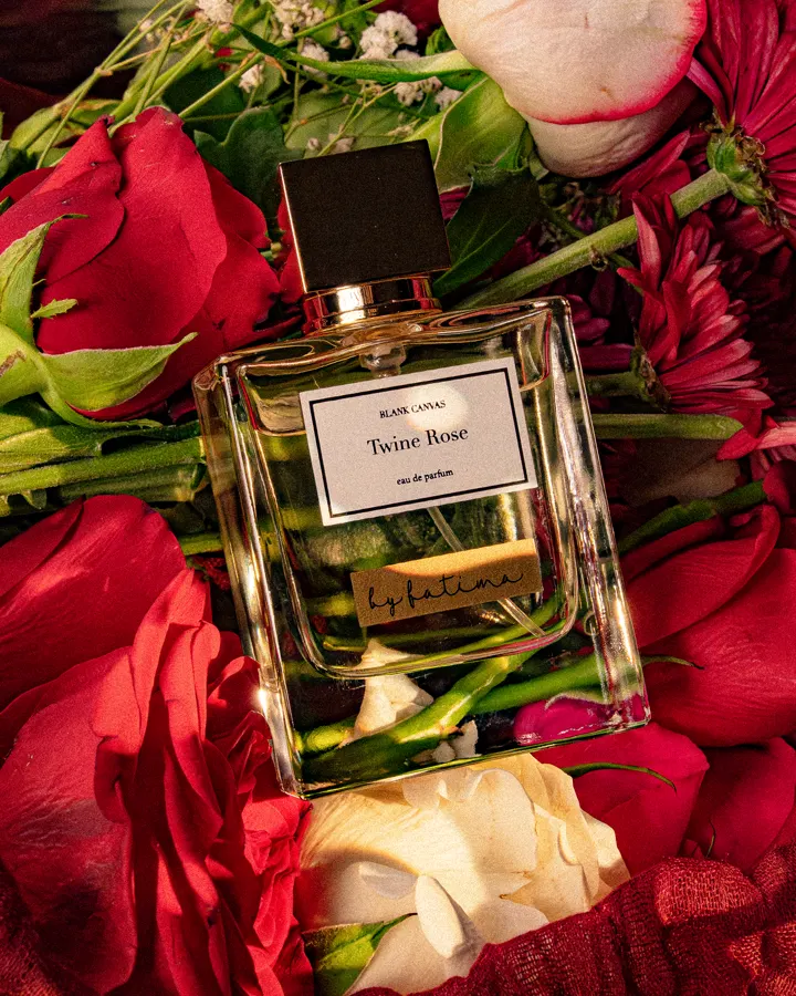 Blank Canvas Twine Rose perfume surrounded by red and white roses